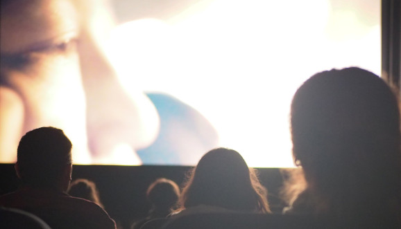 Film auf Leinwand mit Pubbikum von hinten